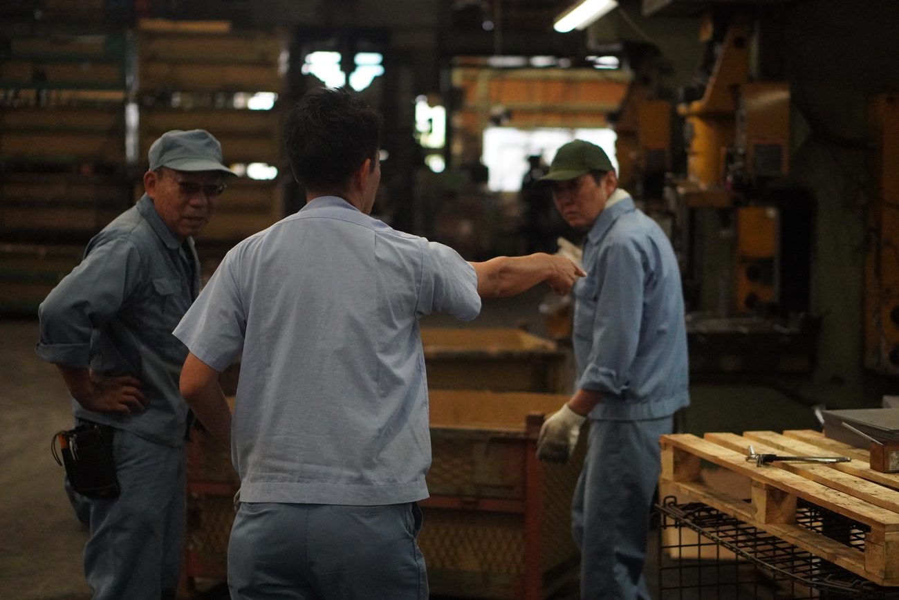 工場内で作業内容を確認している職人たち